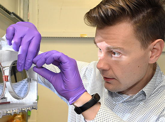 Image showing a scientist wearing purple gloves adjusting spectrometer