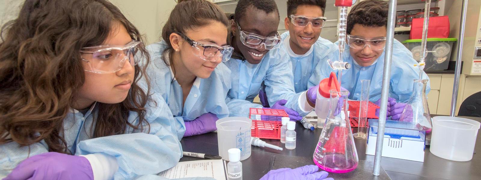 photo of students looing at a chemistry beaker