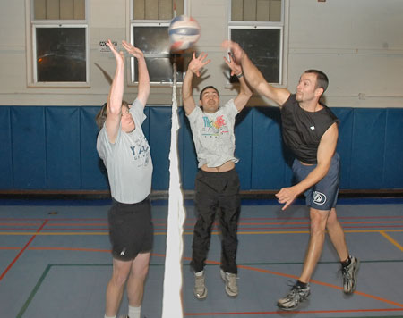 photo of three people playing volleyball