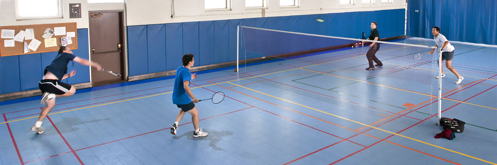 photo of men playing badminton in a gym