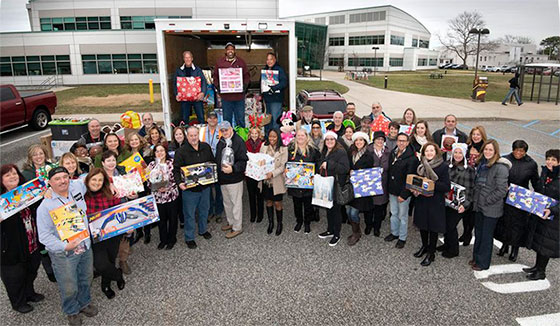 photo of employees holding gift donations