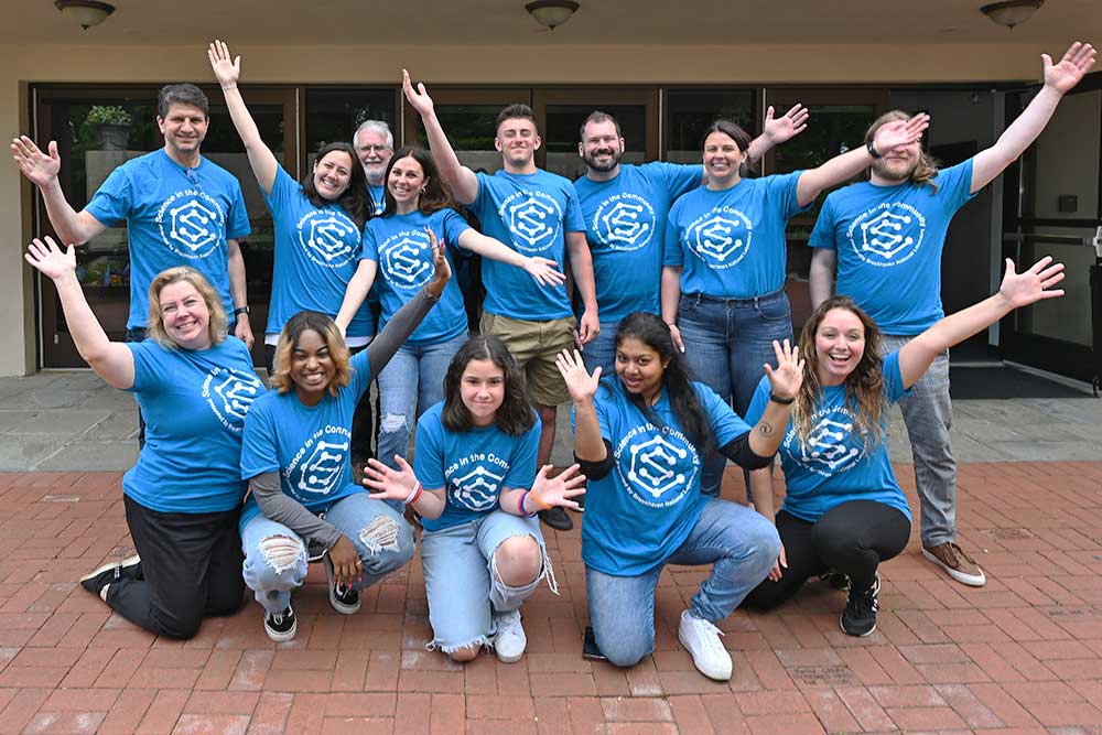 photo of the Science in the Community staff waving in front of the Vanderbilt Planetarium