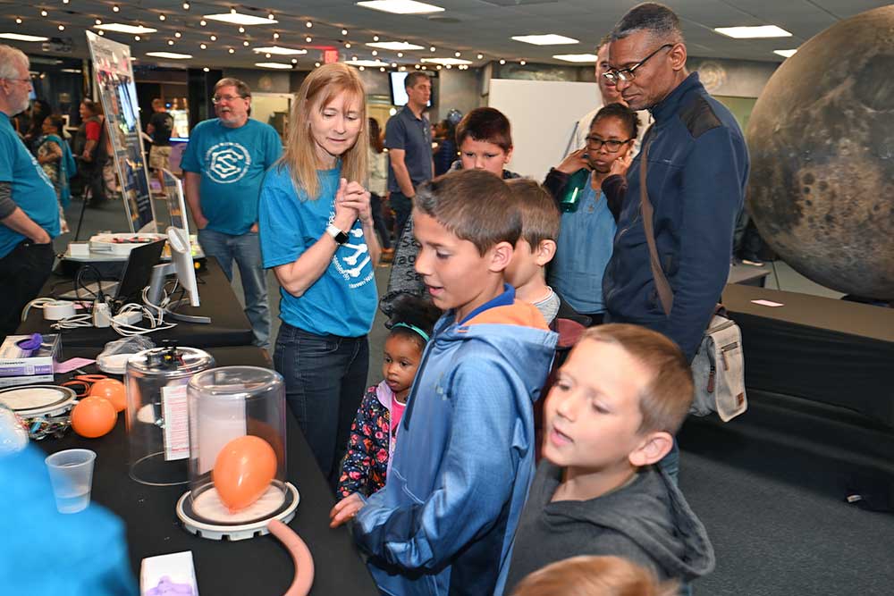 photo of kids looking at a science disaply on a table top