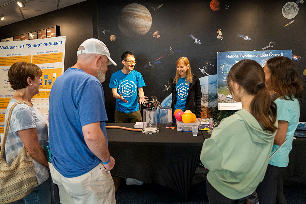 photo of the Science in the Community volunteers presenting a vacuum science demonstration to visitors