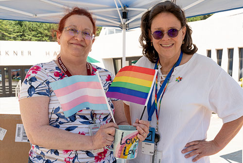 photo of two women next to pride flags