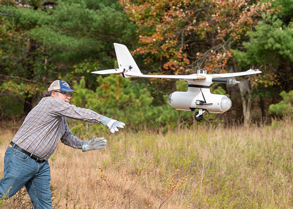 photo of man throwing drone into the air