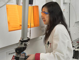 photo of woman using remote maipulator at a hot cell