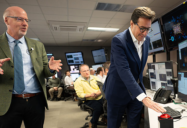Darío Gil presses a red button in the Main Control Room for RHIC