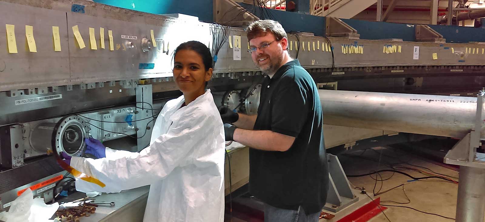 photo of two researchers inside the muon storage ring at Fermilab