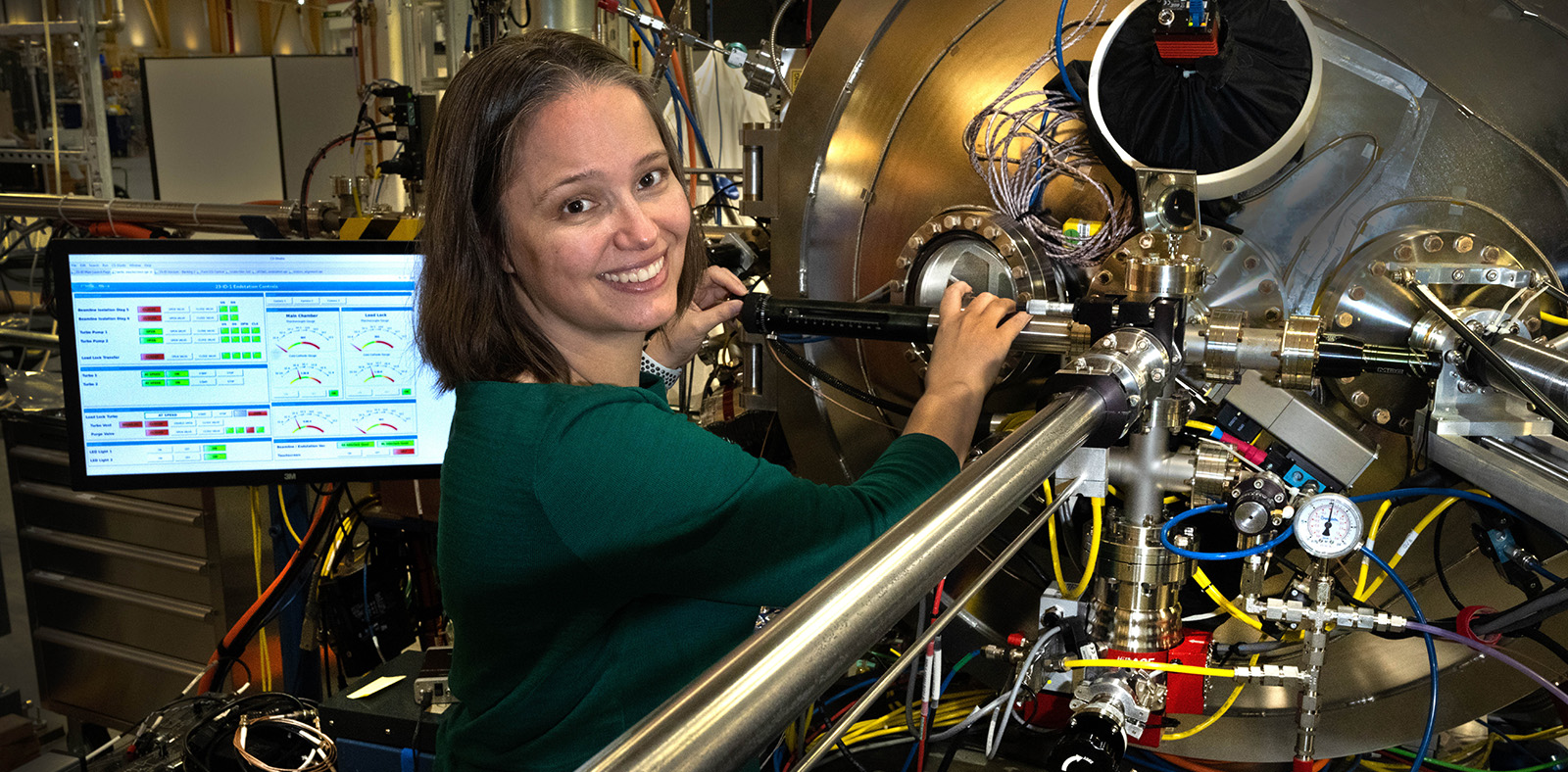 photo of woman standing in front of scientific hardware