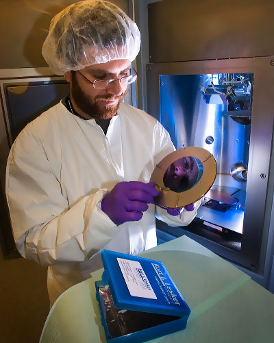 photo of man in a tyvek suit holding equipment