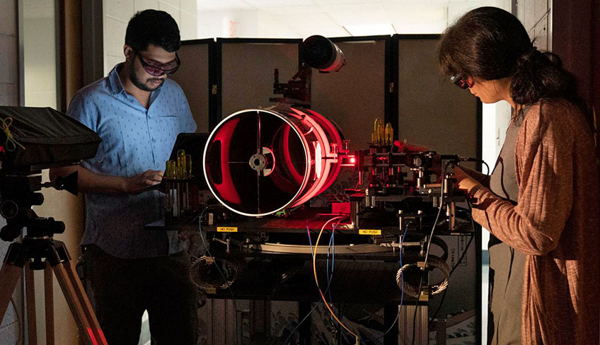 photo of two researchers with free space optical link test hardware