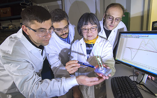 photo of researchers examining chemistry equipment