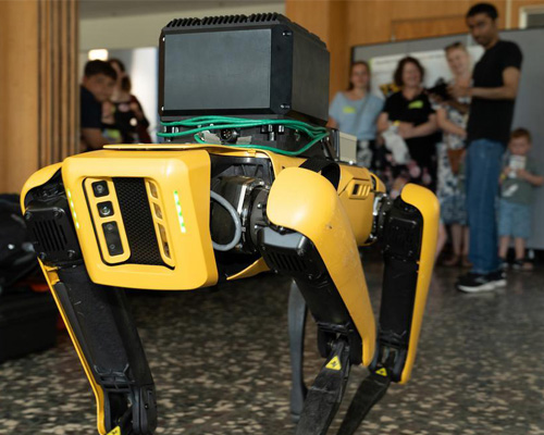 photo of a robot dog with people in the background