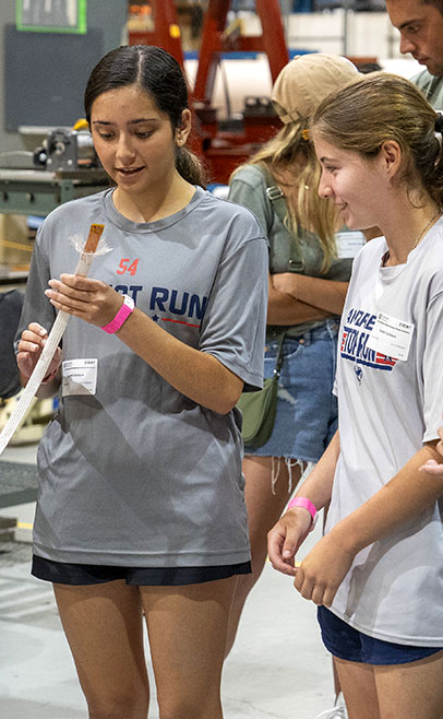 photo of young women looking at a scientific demonstration