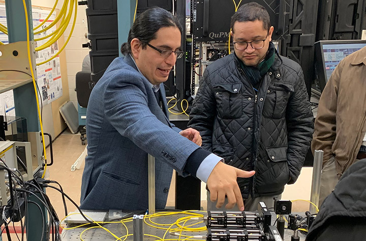 Photo of Eden Figueroa describing quantum network hardware to a group