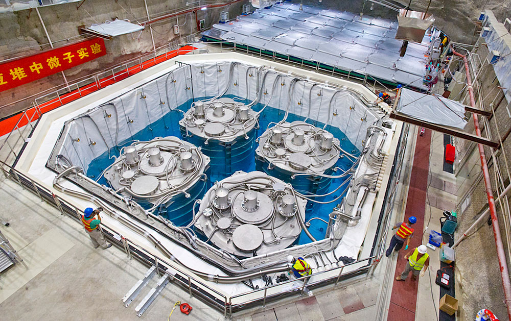 Overhead view of pool filled with four cylinders surrounded by blue liquid