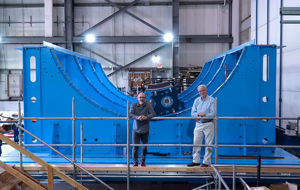 Photo of David Morrison and Edward O'Brien standing next to the curved structure that will supp