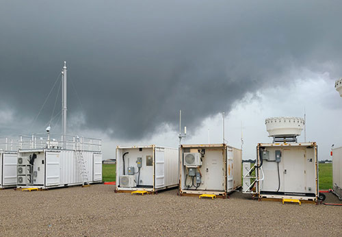 Photo of dark clouds over four white rectangular stations