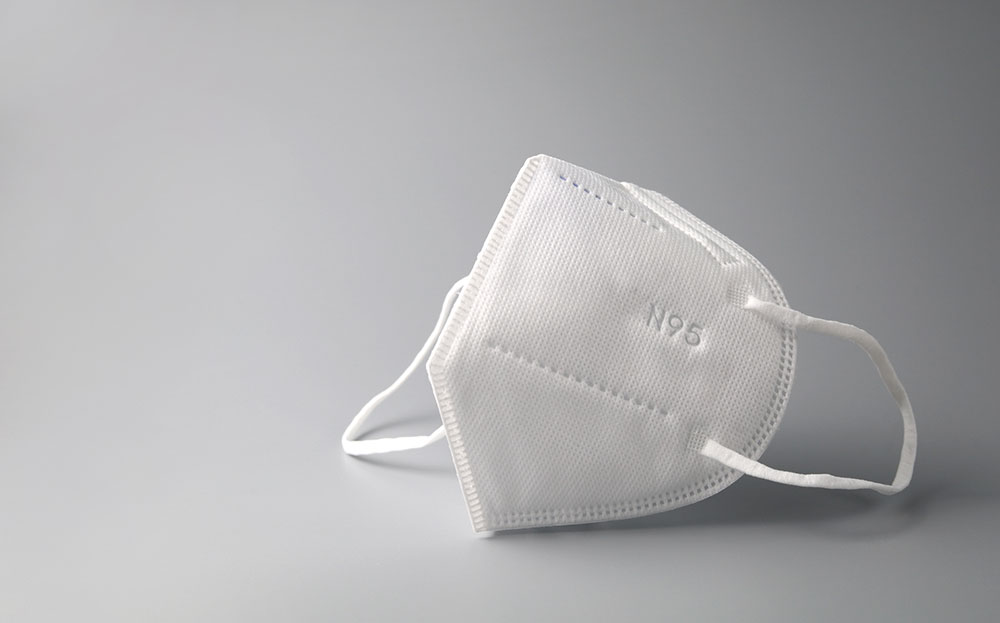 Photo of white N95 mask on a gray background