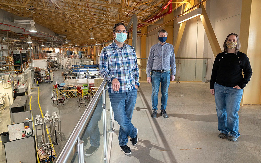 Photo of Lutz Wiegart, Maksim Rakitin, and Andi Barbour stand above the NSLS-II beamline floor