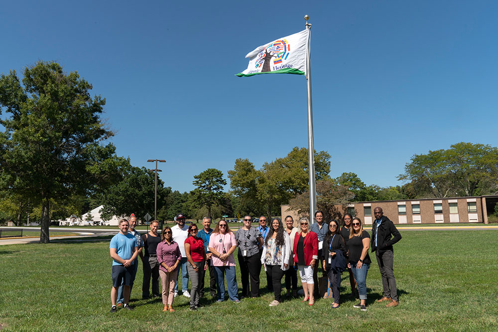 Photo of Hispanic Heritage Group members below HHG flag