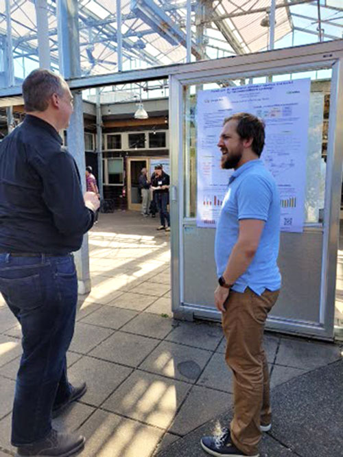 Photo of Mikhail Isaev at ModSim poster session