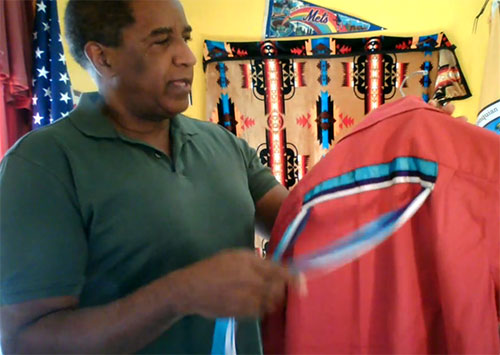 Photo of Nelson Cause displaying a traditional red Ribbon Shirt