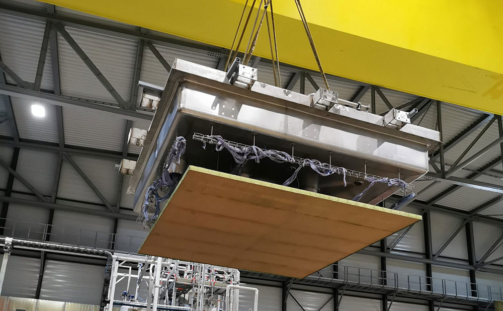 A crane lowers a charge readout plane attached to the top of the cryogenic vessel onto the vessel