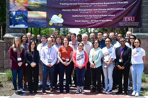 Group of people standing in front of purple workshop banner