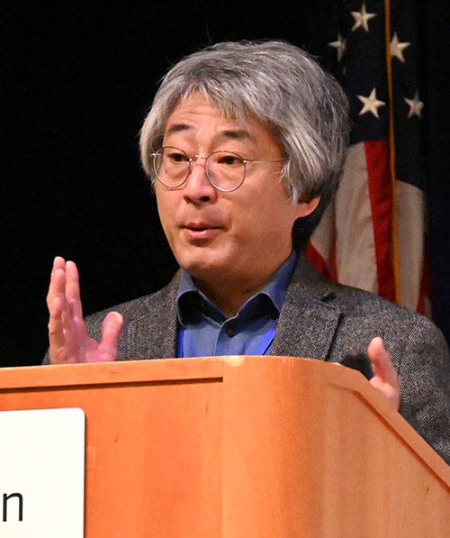 Hiroshi Murayama speaking behind a podium