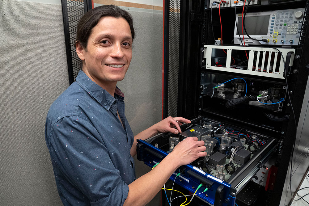 Julian Martinez-Rincon stands with a drawer of electronic equipment