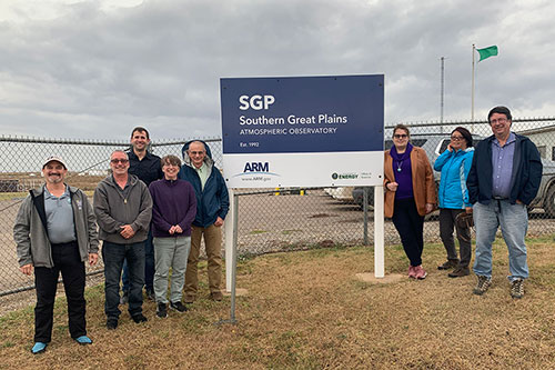 UEC workshop attendees flank the sign greeting visitors at the entrance of the Southern Great Plains