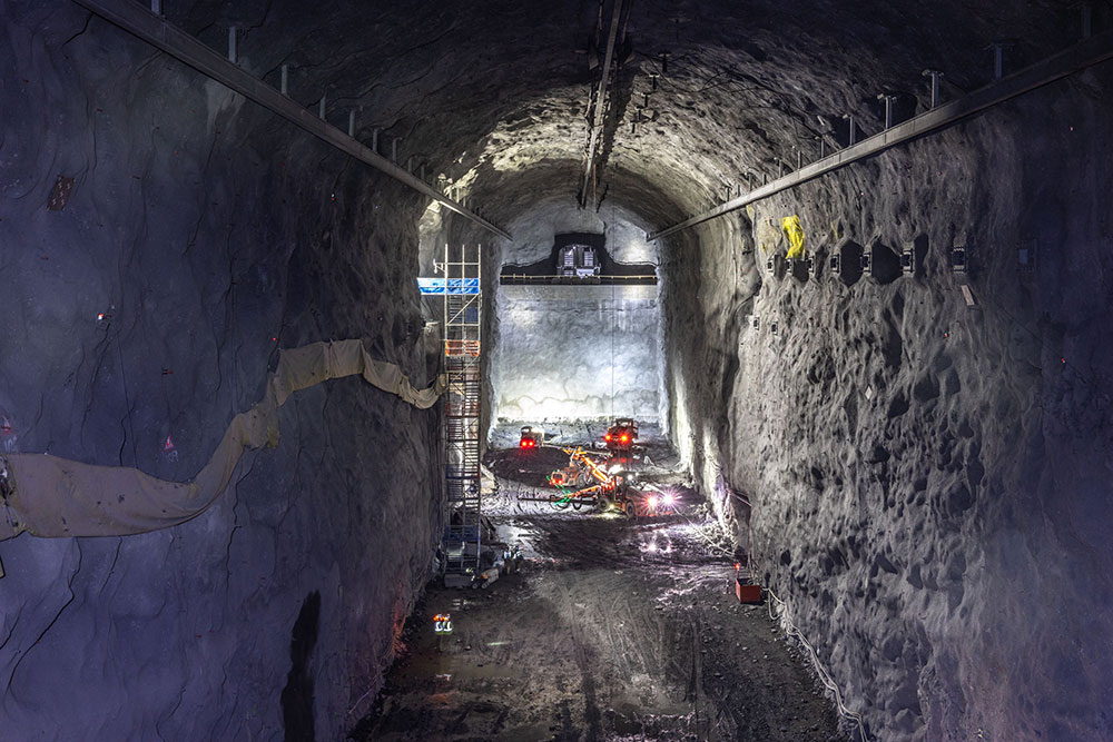 A bird's eye view into a cavern with construction equipment at the bottom