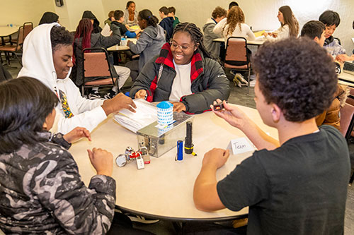 Students smile as they pull contest instructions from a bag