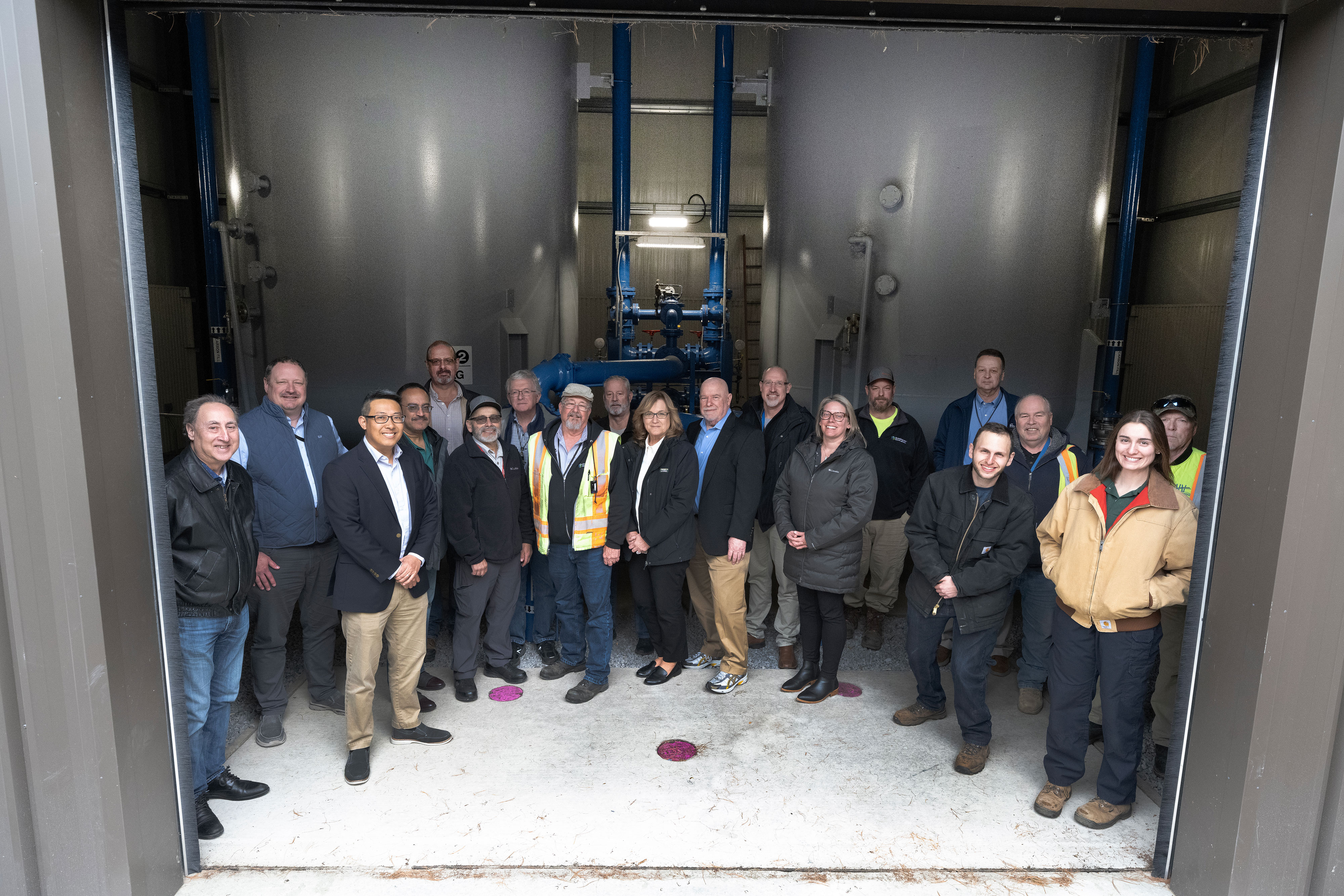 Members of the PFAS Groundwater Remediation Team with the one of two treatment systems 