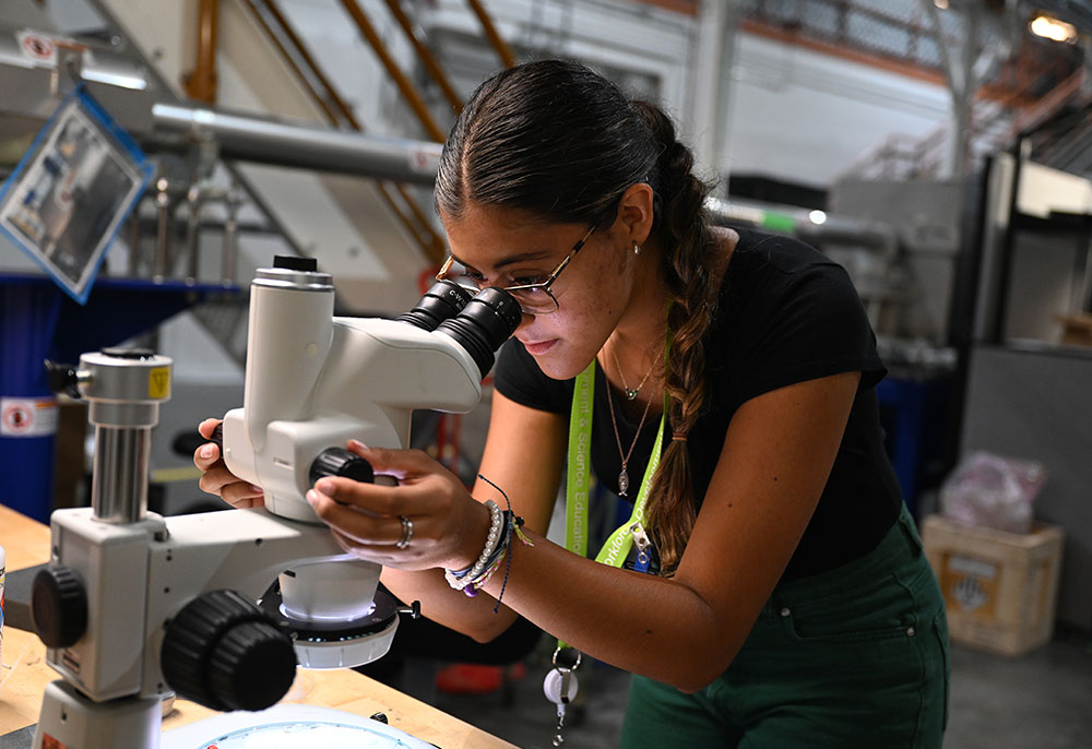 A student peers into a microscope