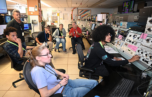 A group of students and staff in a control room
