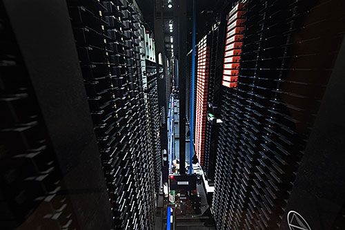 A view inside a storage rack showing a robot that retrieves tapes