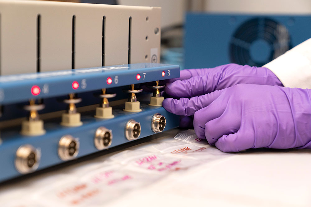 Research wearing purple gloves adjusts equipment
