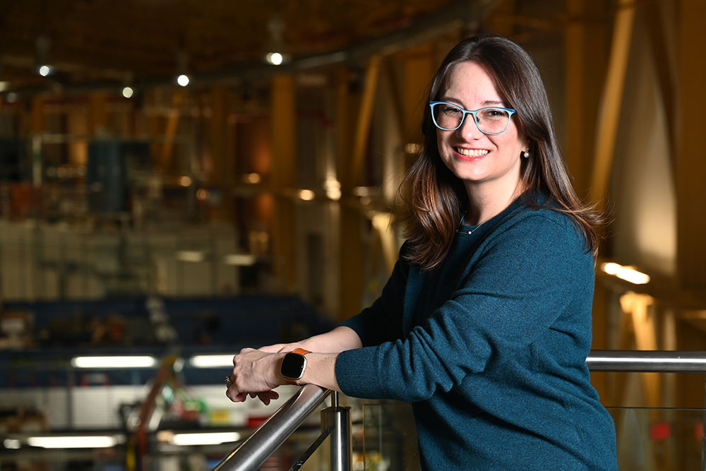 Lacy Jones stands on a balcony above the NSLS-II experimental floor