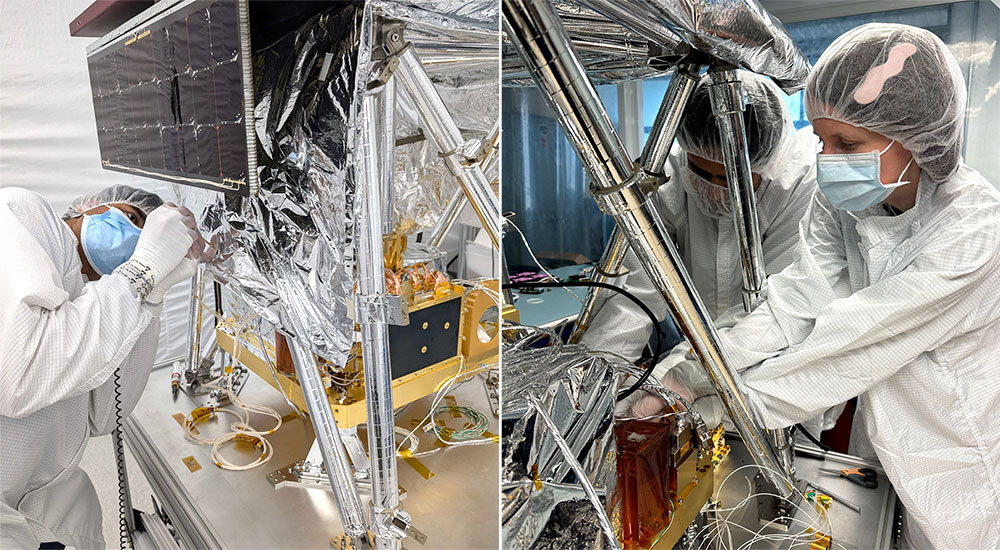 Engineers wearing clean room gear assemble machinery