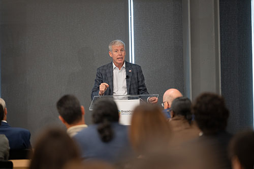 Secretary Wright speaking at a podium in front of a crowded room