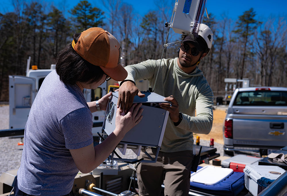 Two researchers adjusting an instrument