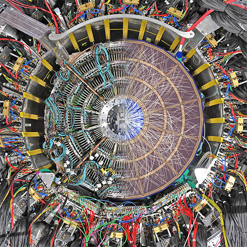 split-screen end view of the sPHENIX detector shows detector components and superimposed particle tr