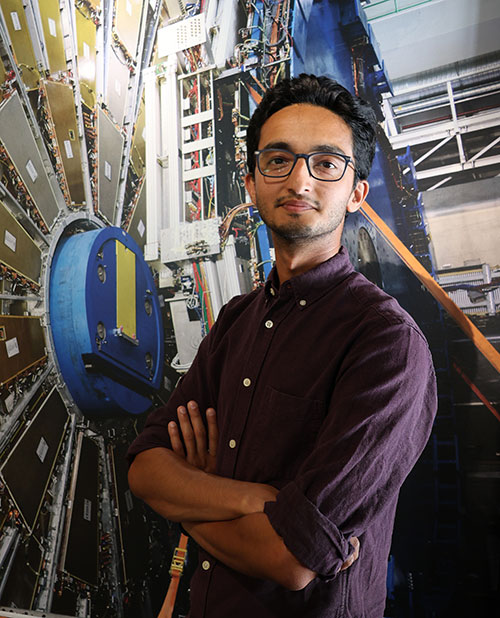Syed Haider Abidi in front of the ATLAS detector at CERN's Large Hadron Collider