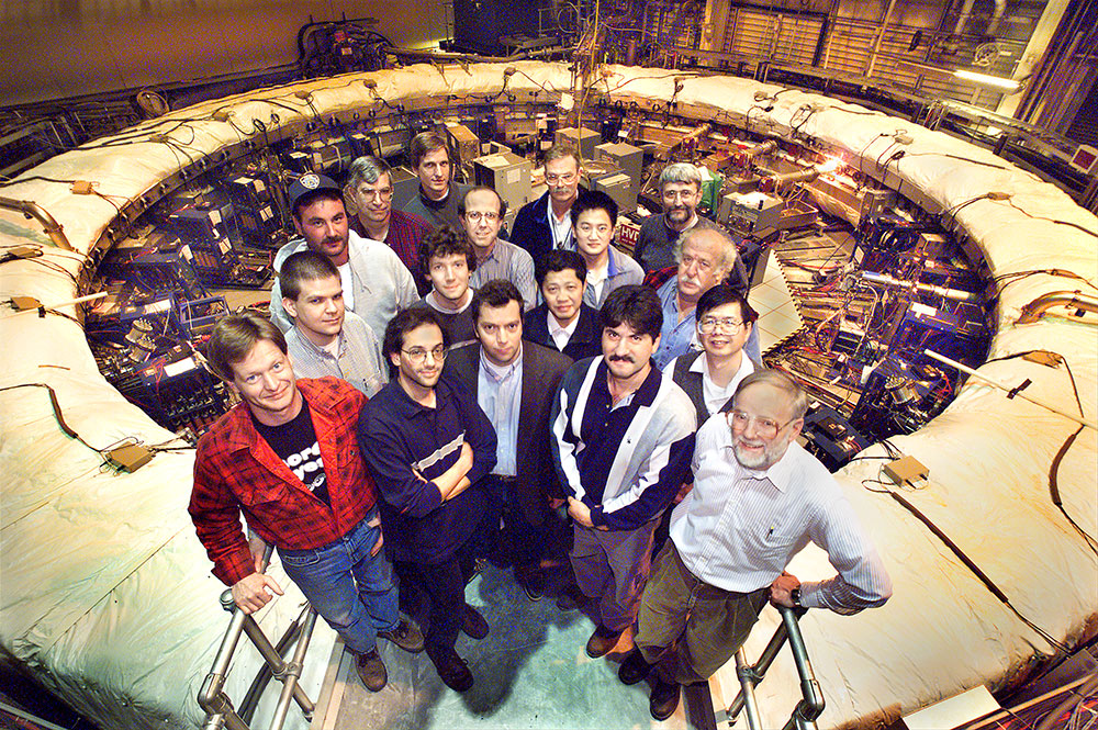 Members of the Brookhaven muon g-2 collaboration pose around the storage ring magnet in 2001.