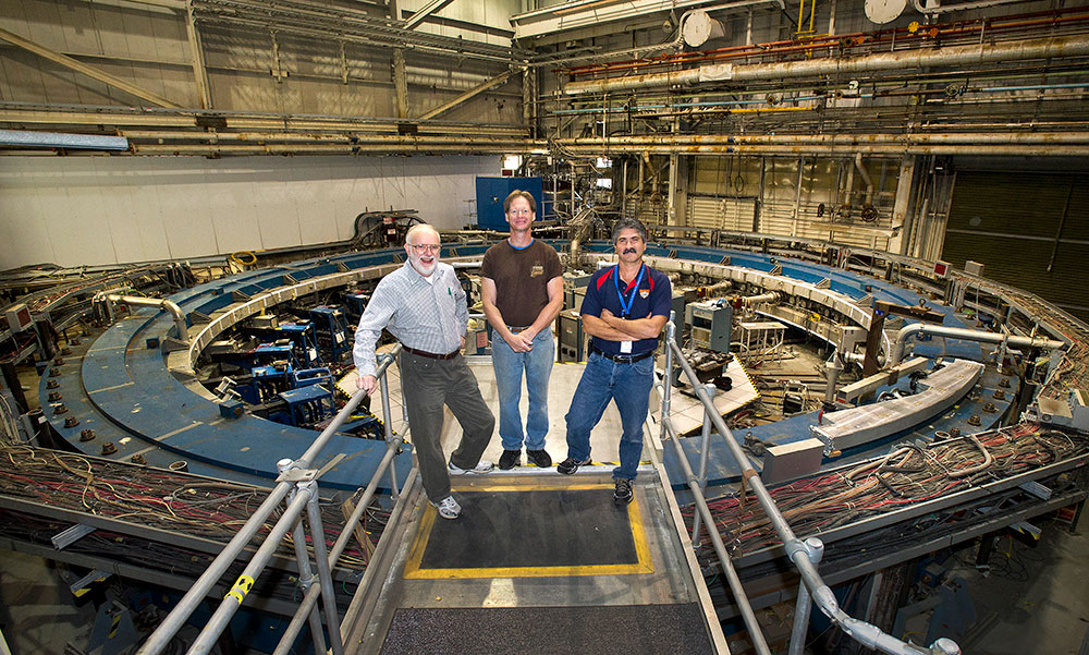 William Morse stands above the 149-foot-circumference storage magnet used for the muon g-2 experimen