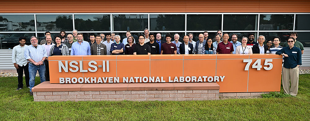 NSLS-II staff in front of NSLS-II sign