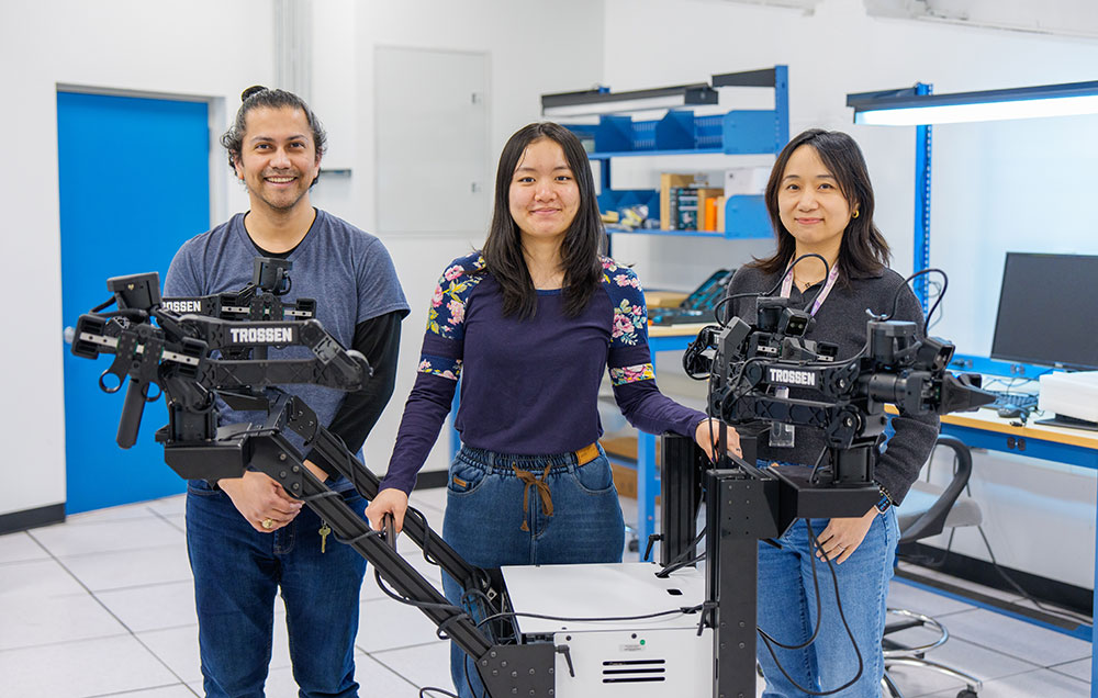 Carlos Soto, Jasmin Lin, and Wei Xu stand with a robotic system in Brookhaven Lab's Scientific 
